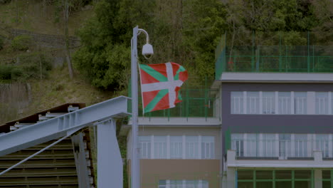 la bandera del país vasco ondea en el viento sobre un edificio en san sebastián, norte de españa