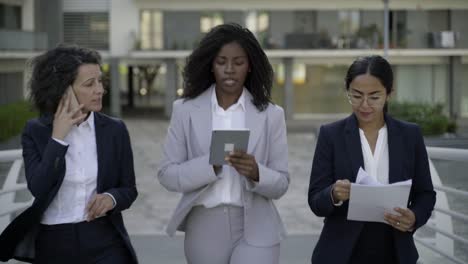 businesswomen with papers and digital devices