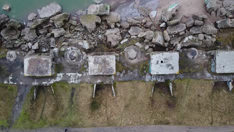 aerial birdseye view of abandoned seaside fortification building at karosta northern forts on the beach of baltic sea in liepaja in overcast spring day, ascending drone shot