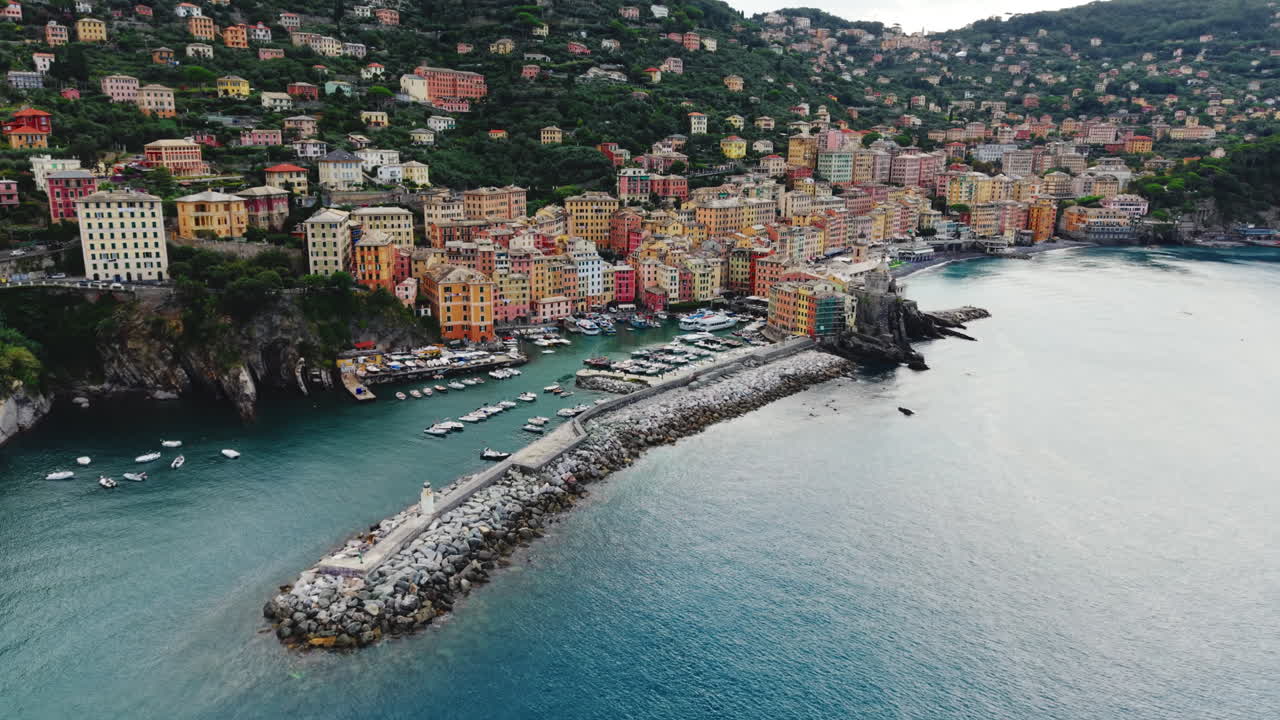Drone che si alza e si allontana sulla baia di Camogli, il porto e il paesaggio montano