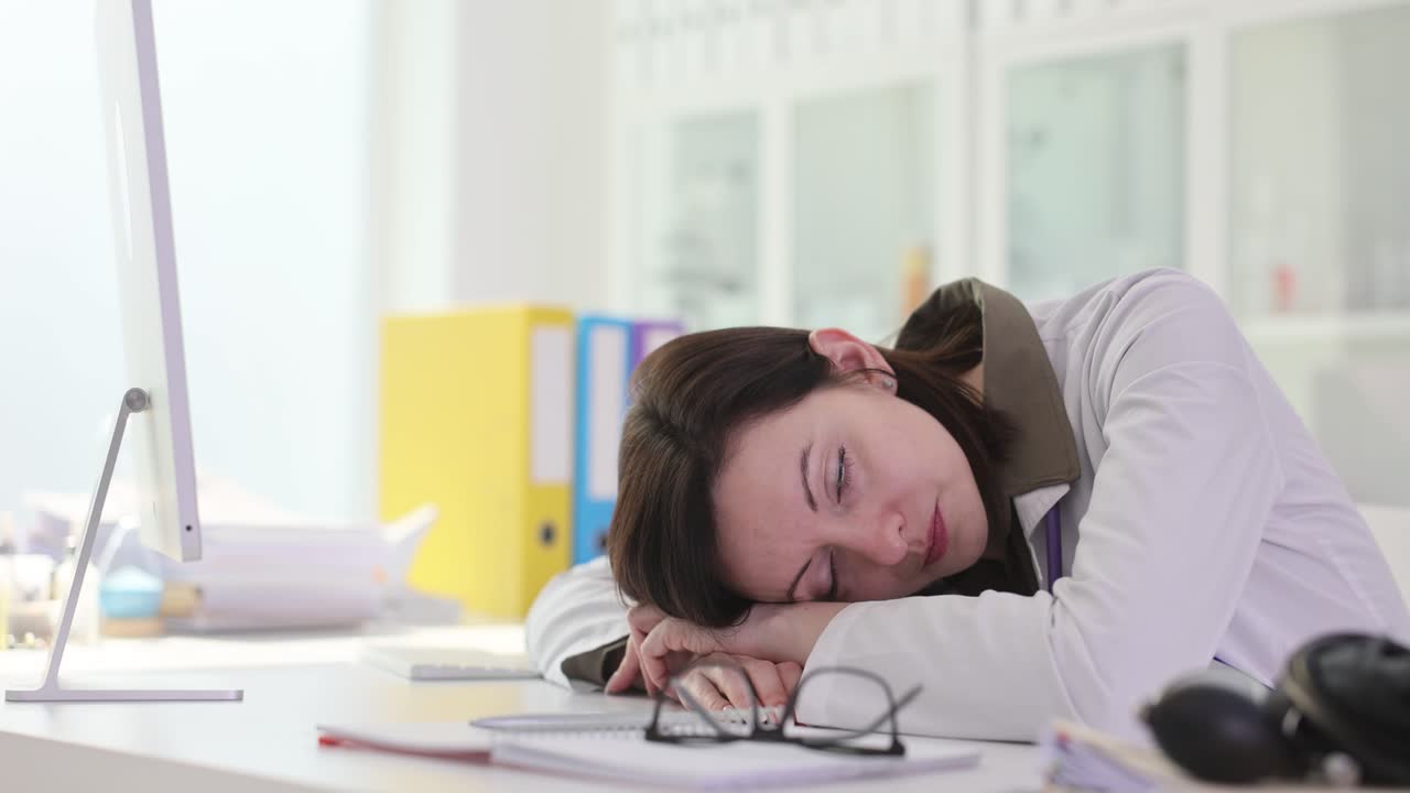 Exhausted doctor or medical professional sleeping at her desk
