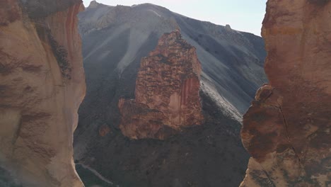 drone slow epic fly through rock formation at leslie gulch oregon to reveal rock spire on hillside in morning back light