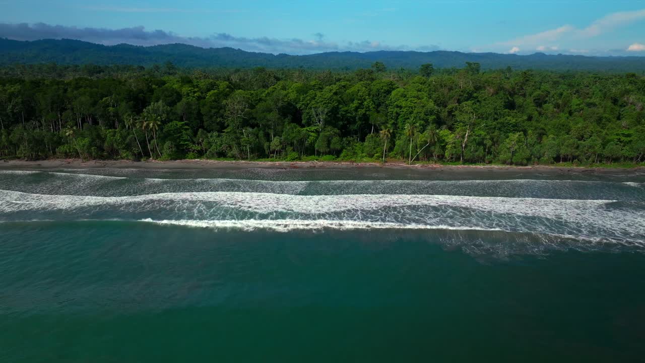 Untouched remote pristine coastline waves Cape Wom Papua New Guinea PNG aerial drone Madang Wewak Kavieng Vanimo Tufi sunny beach blue sky tranquil tropical shoreline East Sepik Province right slowly