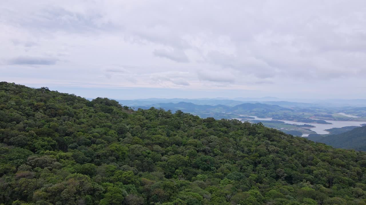 rising drone shot of extrema - minas gerais, brazil, lake views, low rainforest