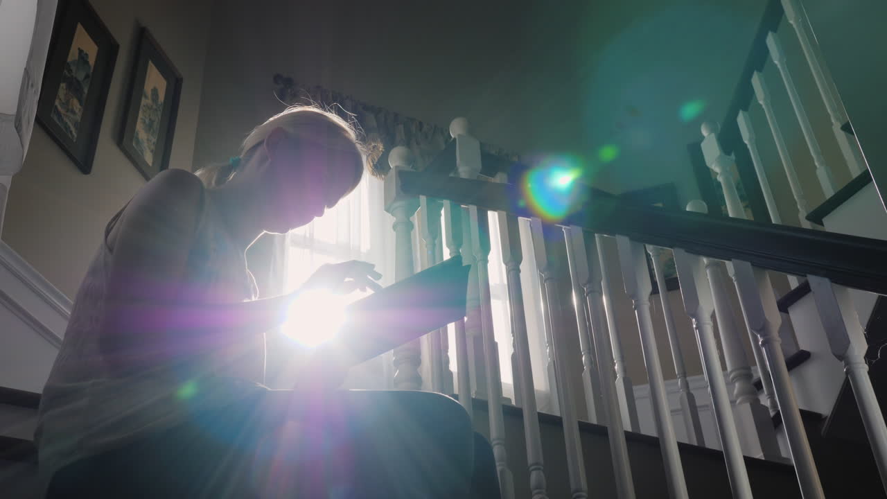 mujer retroiluminada usa tableta en las escaleras