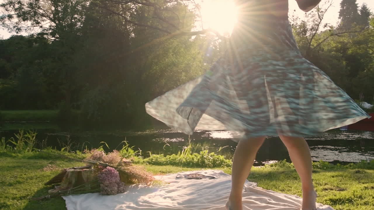 Happiness concept, hipster girl rotating in circles expressing positive feelings, showing ecstatic emotions during picnic in park, bright light sun rays, slow motion