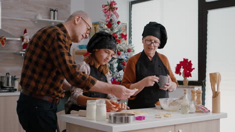 grandparents teaching granddaughter how to make xmas homemade gingerbread