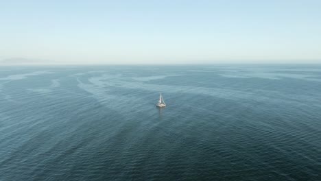 aerial of tourist sailboat on the pacific ocean during sunset, near the coast of santa barbara, california