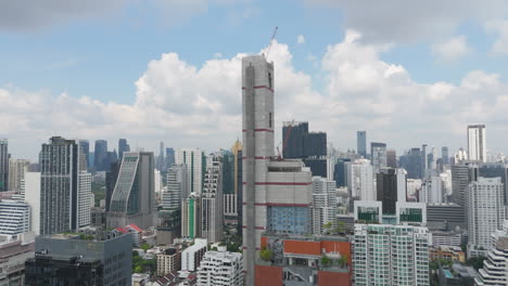 sleek residential highrise stands tall over central bangkok’s urban landscape