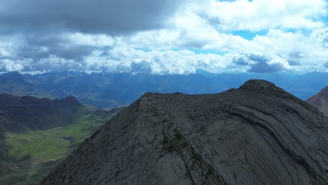sweeping aerial footage of valle de ip, aragón with towering rugged peaks under expansive skies. dramatic lighting enhances the breathtaking natural landscape, ideal for nature lovers