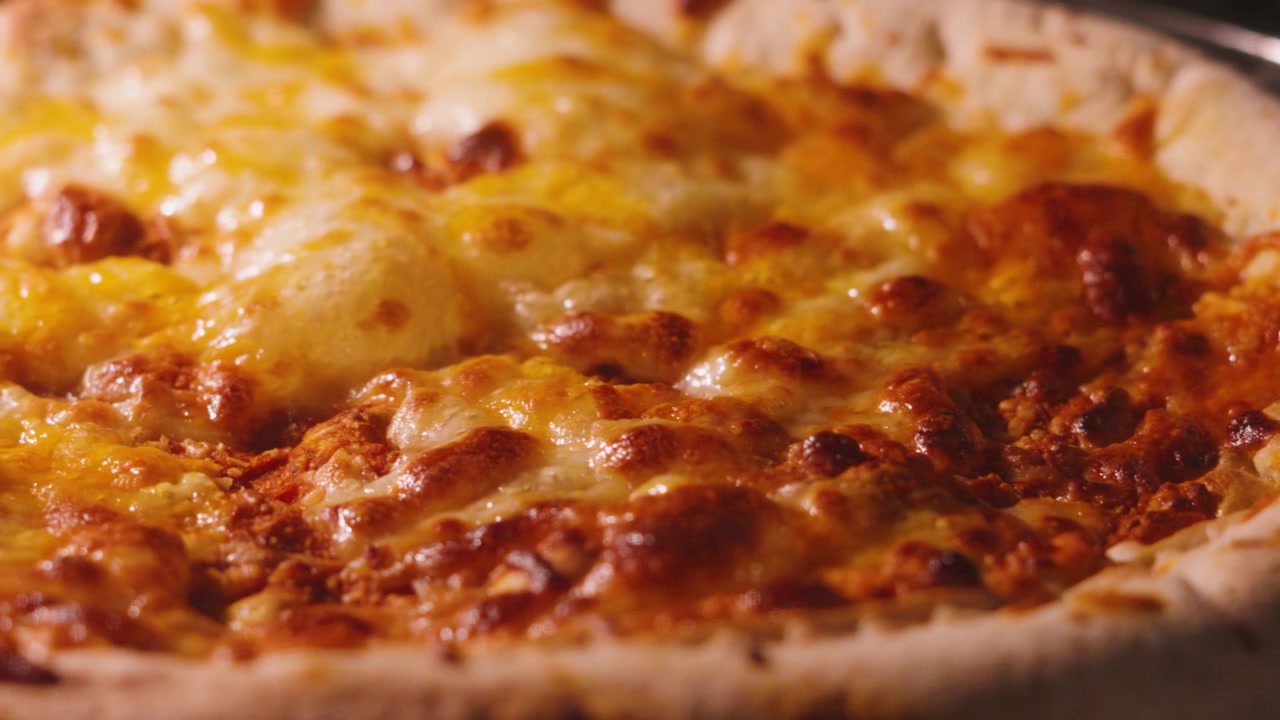 Ripresa a movimento lento di una classica pizza Margherita con bordo ripieno di formaggio e pomodoro, con mozzarella che bolle mentre cuoce in forno caldo. 4K.