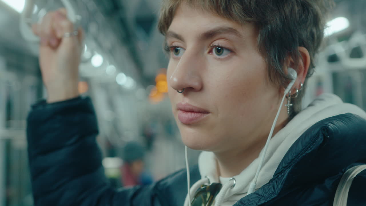 Young Woman in Earphones Traveling on Underground