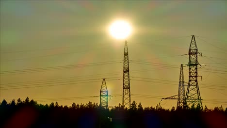 sunset over the forest and the pillars of high-voltage power line. time lapse.