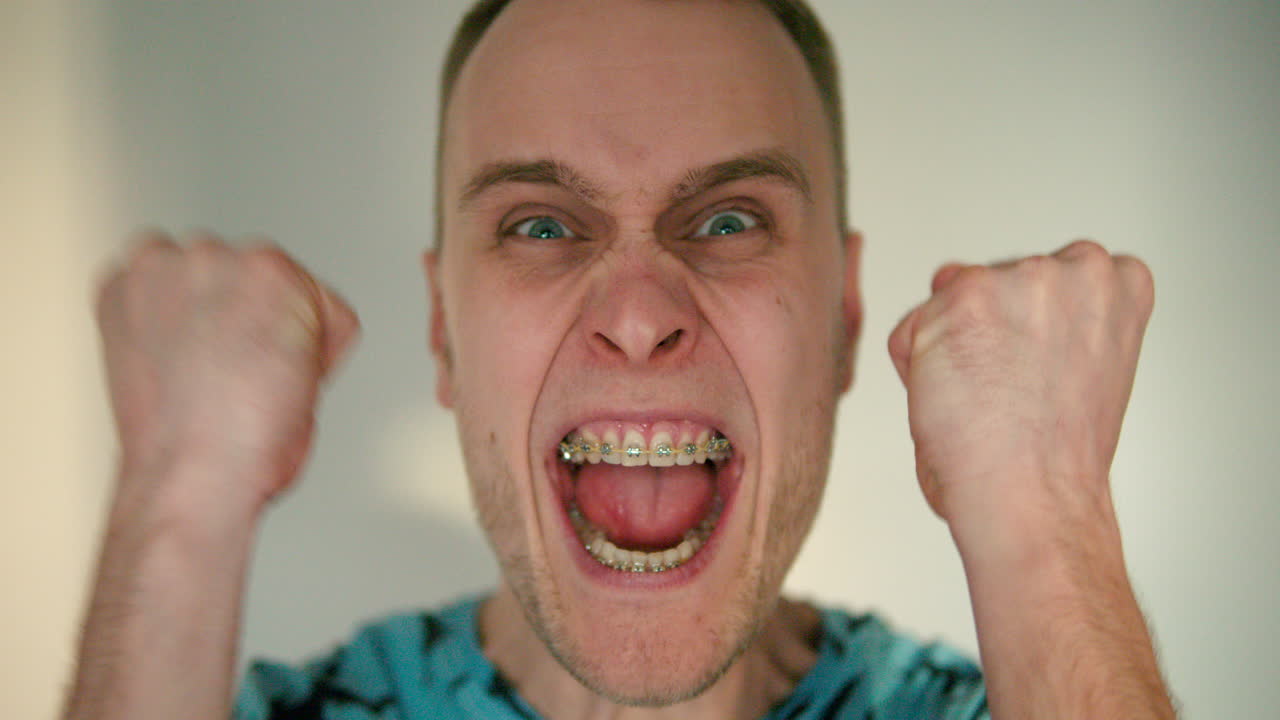 primer plano de un joven felizmente agresivo y aprieta los puños