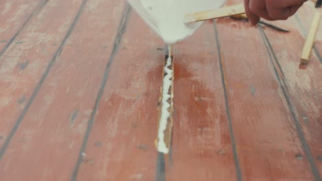 Pouring cascamite glue into wooden boat wheelhouse roof plank repair