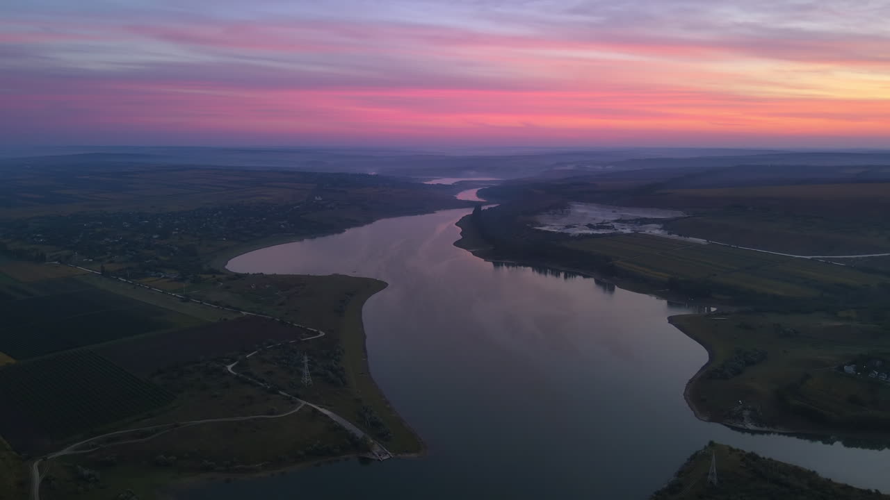 Aerial drone view of the Duruitoarea natural reservation at sunset in Moldova. River and village, hills and fields