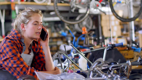 Woman-talking-on-mobile-phone-at-workshop-4k