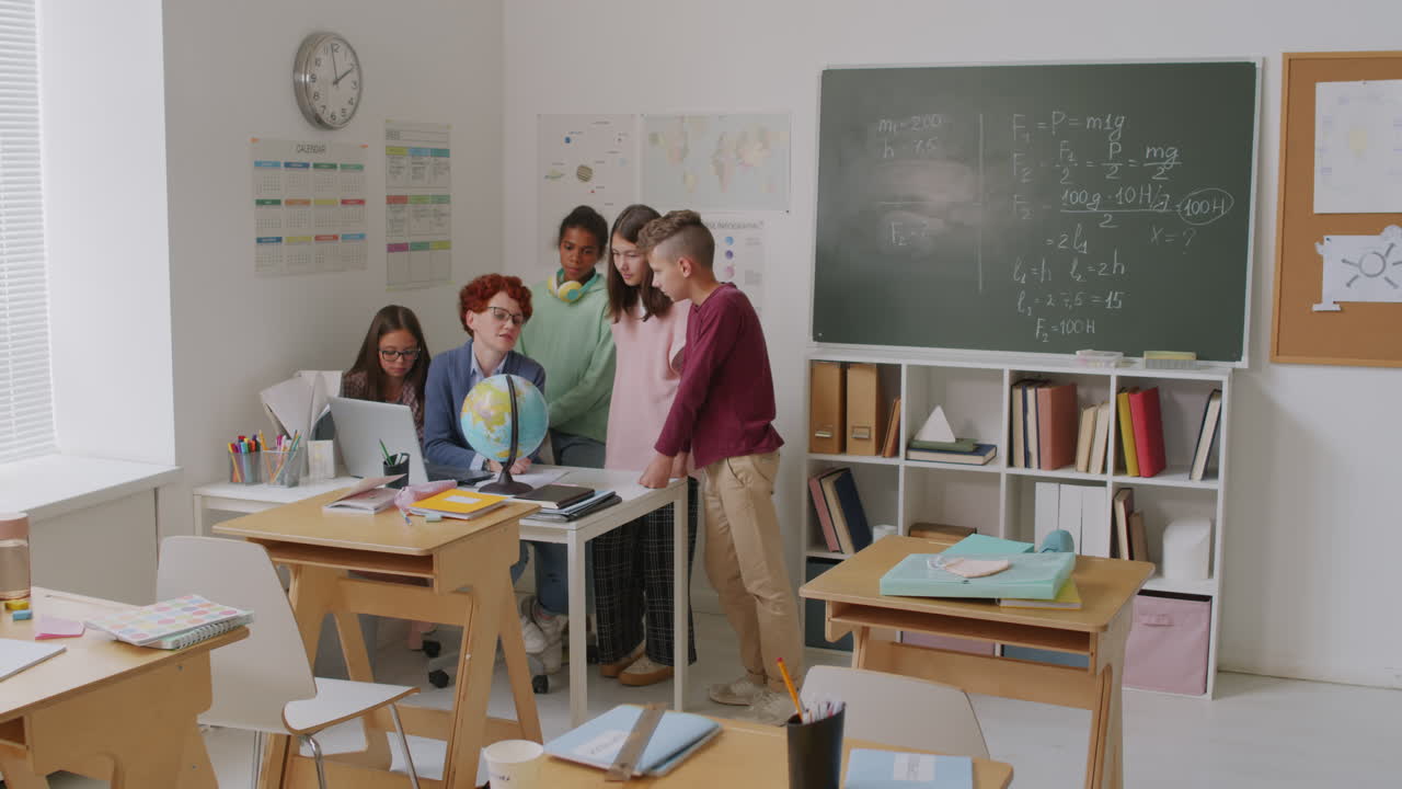 Geography Teacher Talking to Kids in Classroom