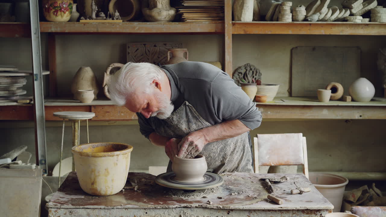 Senior Potter Shaping Clay on Wheel