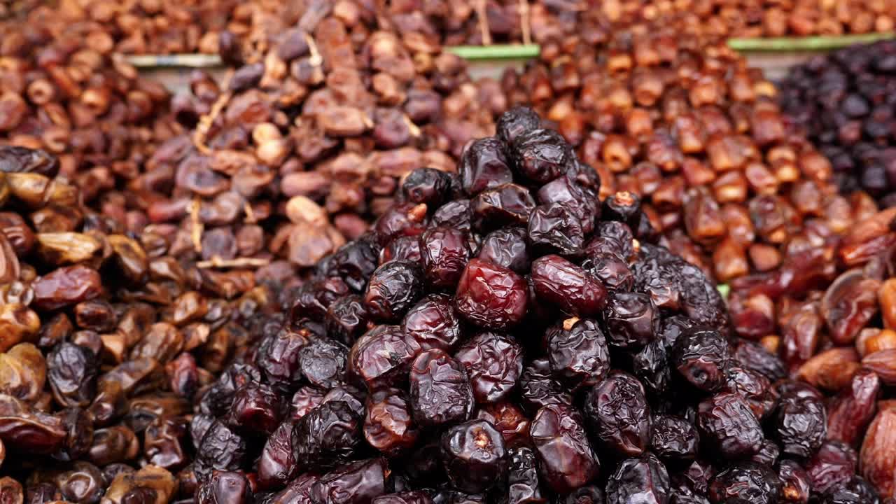 Variety of fresh Moroccan dates, shop display in the Medina of Marrakech (Marrakesh), Morocco. Healthy food snacks, high in vitamins and protein. 4k food background footage.