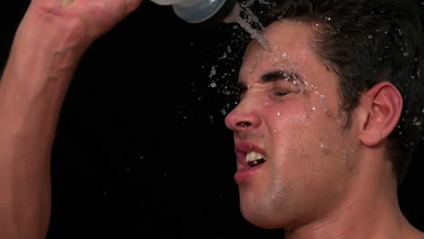 sportsman pouring water over his face