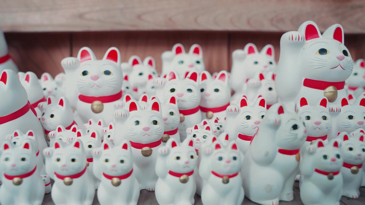 Satoja kuuluisia valkoisia Maneki Neko -kissahahmoja Gotokuji-temppelissä, korostaen rakastettua onnen, vaurauden ja japanilaisen kansanperinteen symbolia