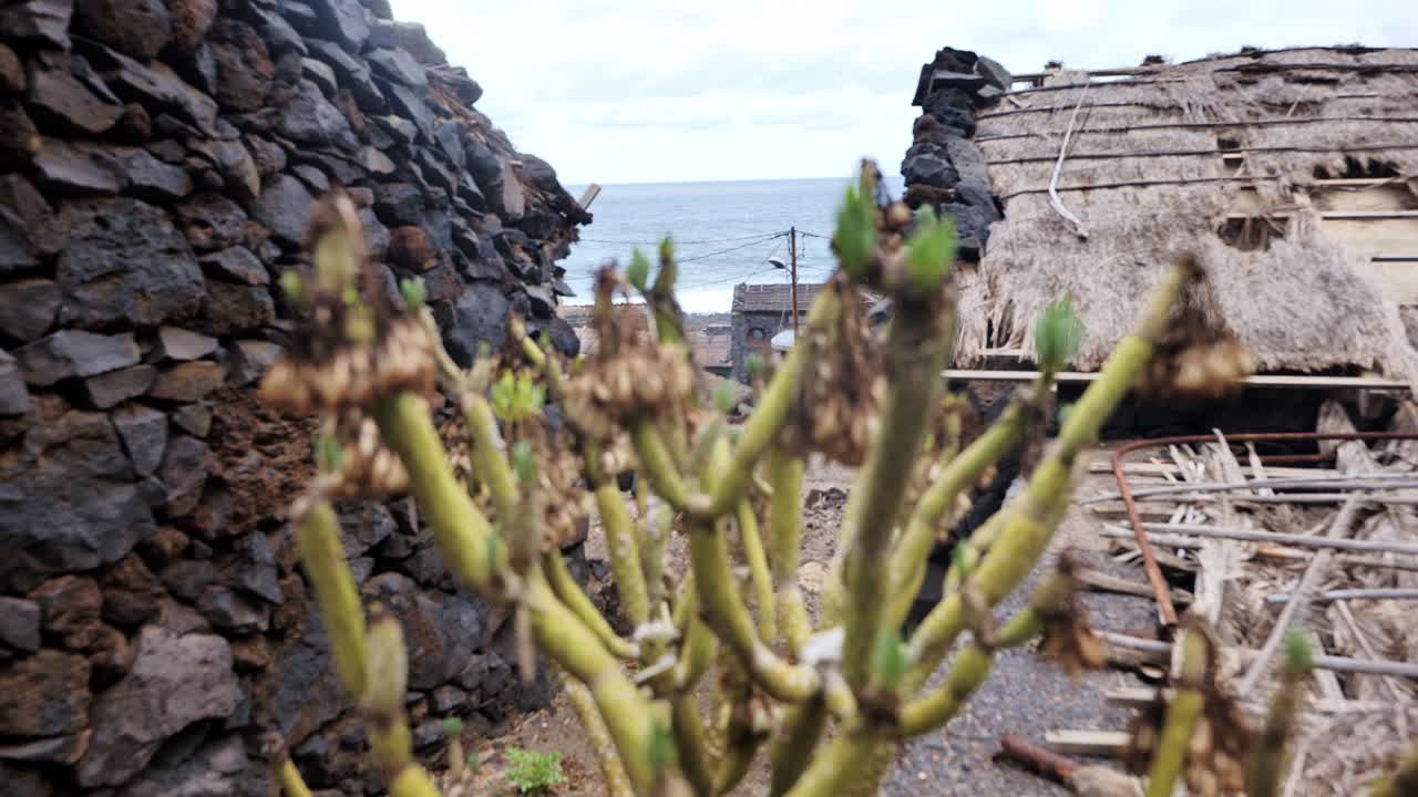 Traditional coastal homes and rocky textures frame Atlantic horizon in focus, 4K