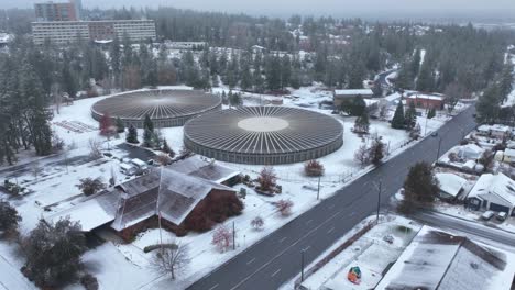 vista aérea empujando hacia grandes depósitos de agua en un barrio suburbano cubierto de nieve