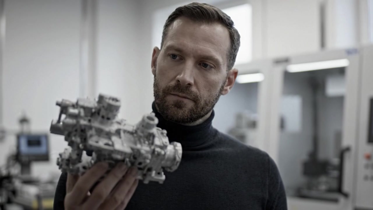 An Engineer Analyzes a Precision Engine Component in a High-Tech Laboratory Environment, Focusing on Innovation and Design to Enhance Performance and Efficiency.