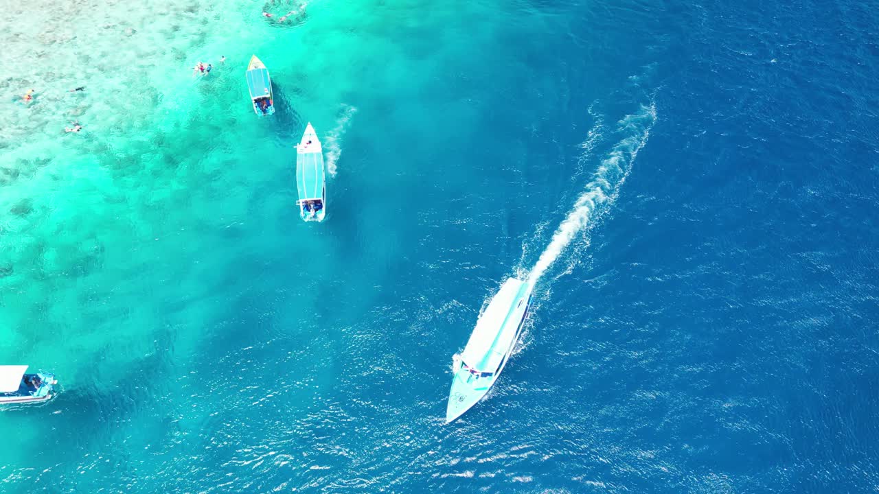vista aérea de pájaro sobre la playa de gili meno, ubicada entre las idílicas islas gili de indonesia, los barcos están flotando sobre las aguas azules cristalinas