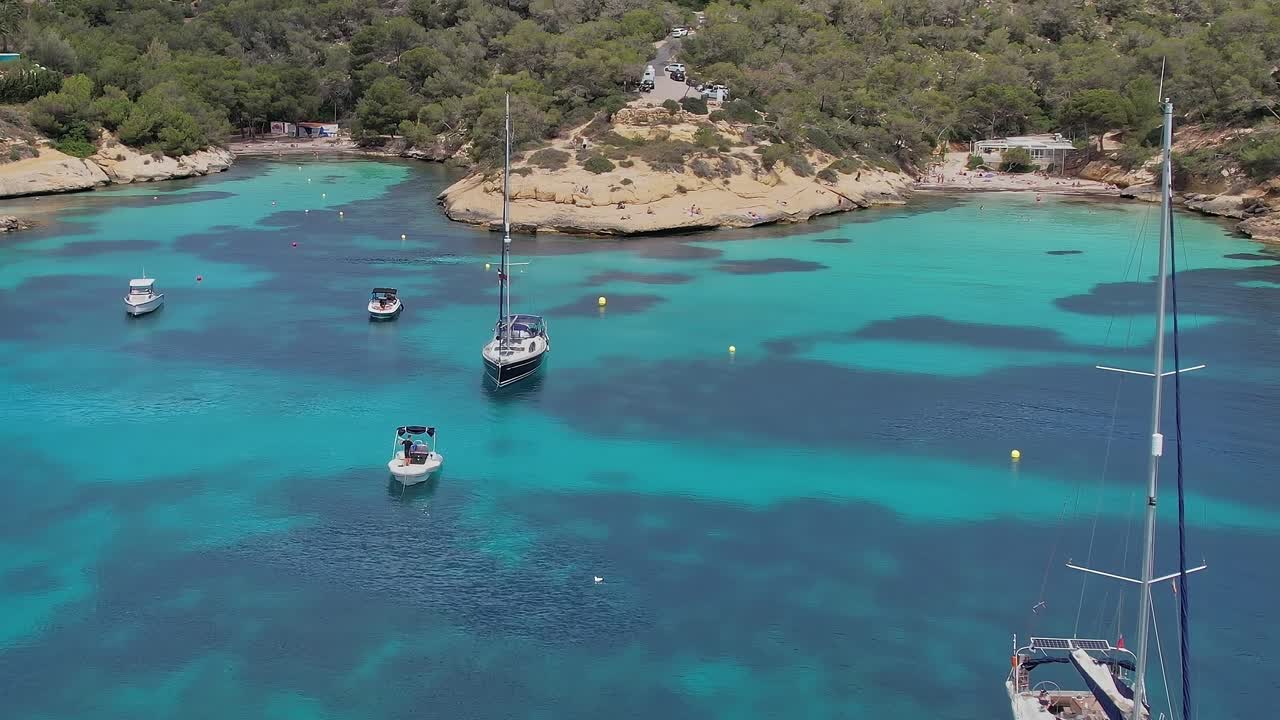 Boats floating on clear water in Mallorca, Spain