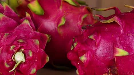 a detailed view of clustered dragon fruits showcasing their vibrant pink skin and unique texture.