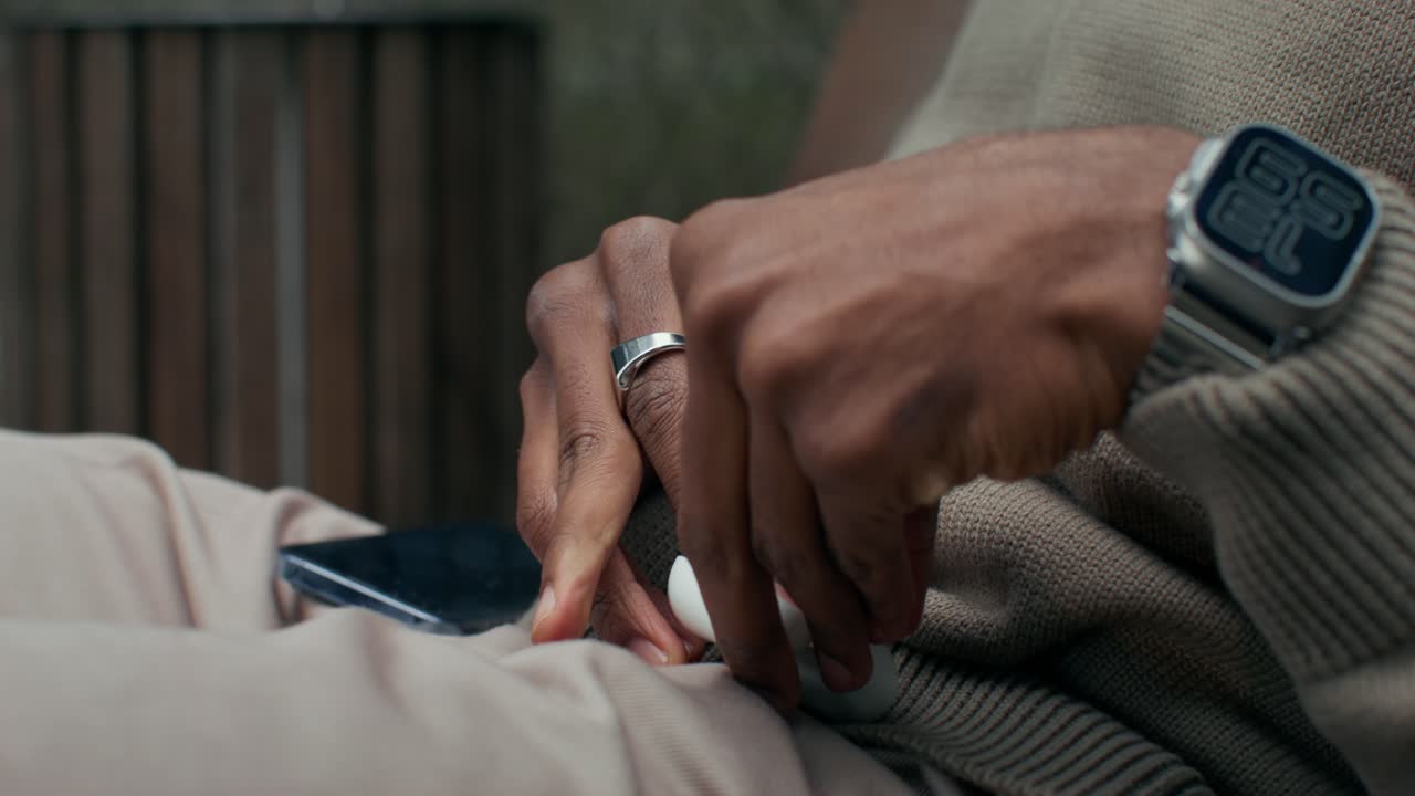 Person Putting Earbuds into Case