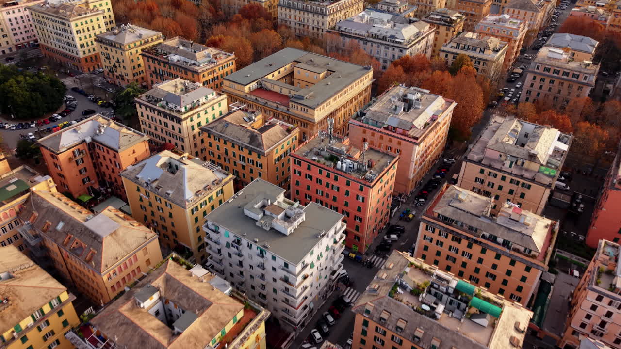 Letecký záběr z dronu, který letí nad barevnými střechami obytných budov v centru Janova