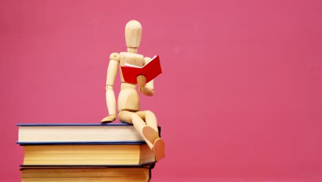 figurine sitting on stack of book