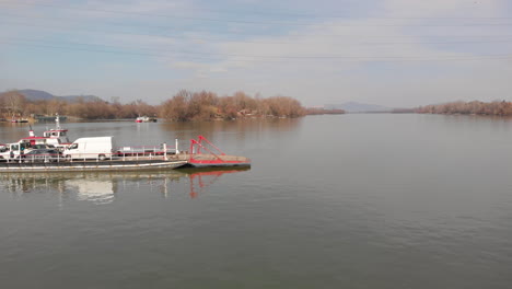 pull back aerial shot of a ferry boat on water carrying cars and people