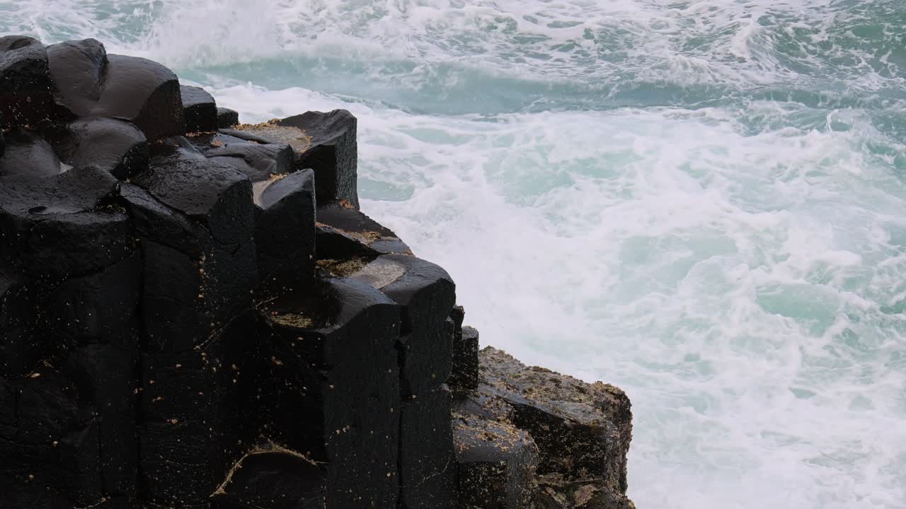 olas dinámicas del océano golpeando un rompeolas escarpado