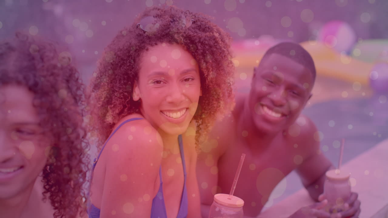 Smiling friends enjoying drinks by pool with colorful bokeh animation overlay