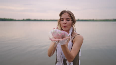 a young female artist shows a soap bubble show by blowing up large soap bubbles with her hands in slow motion