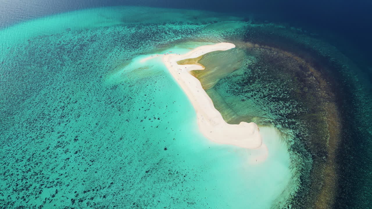 Droneoversigt over en buet sandbanke i Coron-bugten, Palawan, Filippinerne, omgivet af roligt turkisblåt vand med dramatiske bjergsilhuetter i baggrunden.