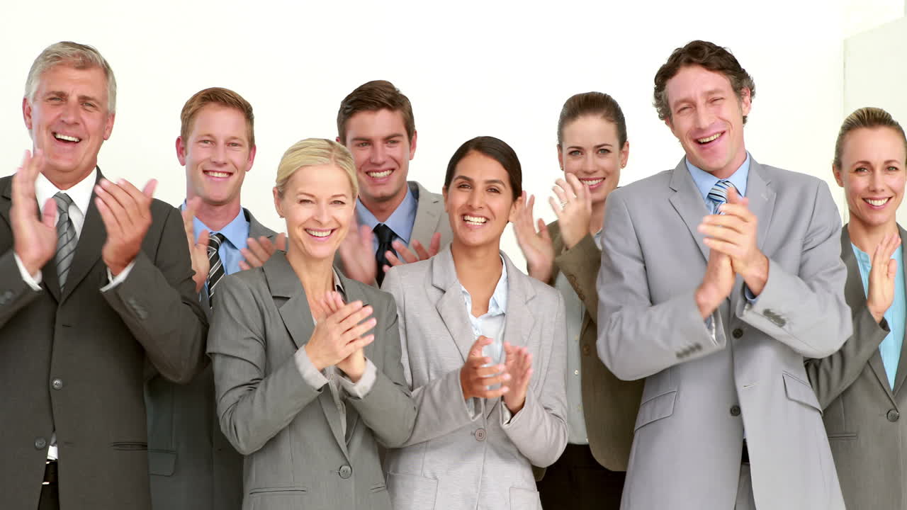Business people applauding in front of camera