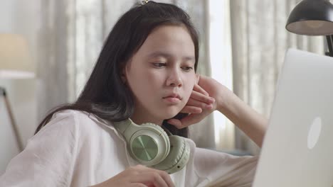 teenage girl studying on laptop