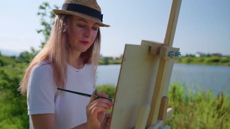 woman painting outdoors by a lake