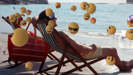 man relaxing on beach with floating emoji animation over ocean background