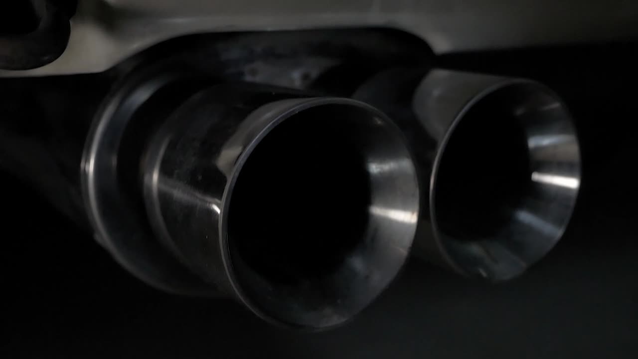 A close up of a rear exhaust tip on a sports car. A simple camera tilt brings the subject into and out of frame.