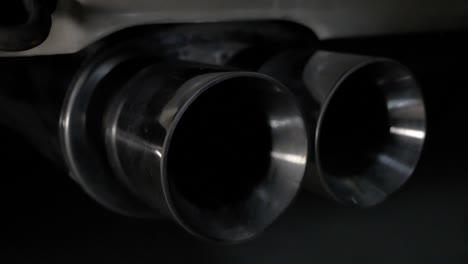 a close up of a rear exhaust tip on a sports car. a simple camera tilt brings the subject into and out of frame.
