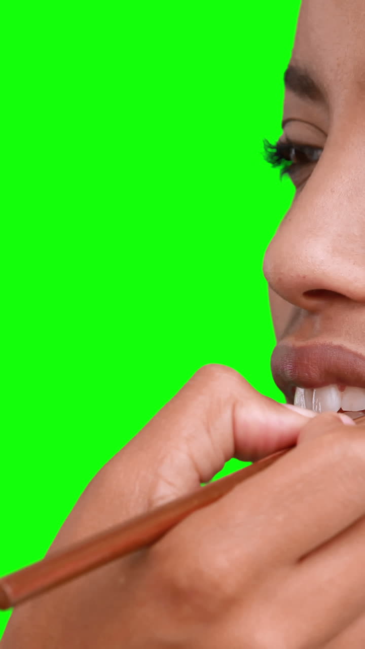 artista de maquillaje poniendo brillo para los labios en la cara de las modelos