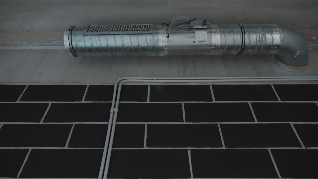 slow establishigng shot of air conditioning vents and pipes in a buildings basement