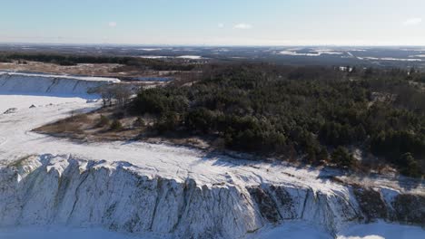a snowy quarry edge with trees and open fields near caledon village, ontario