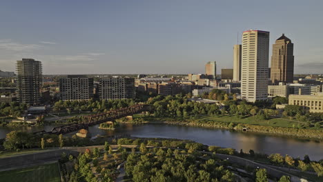 columbus ohio aerial v58 low flyover scioto greenway a lo largo de la curva del río capturando el puente del tren, el distrito de la arena y el paisaje urbano del centro con los resplandores del atardecer - filmado con mavic 3 pro cine - 21 de septiembre de 2023